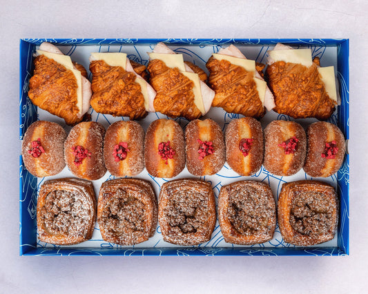 Bakehouse picnic party box with mini ham & cheese croissants, raspberry doughnuts, and banana caramel danish.