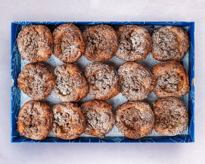 A box of mini apple crumble sourdough croissant danish with brown sugar topping.