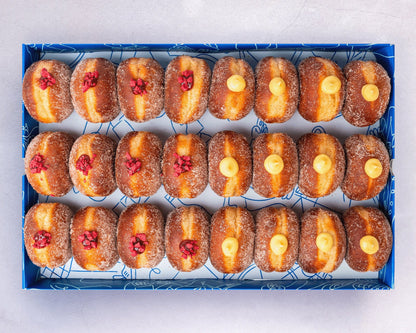 A box of mini doughnuts with vanilla custard and raspberry jam fillings.