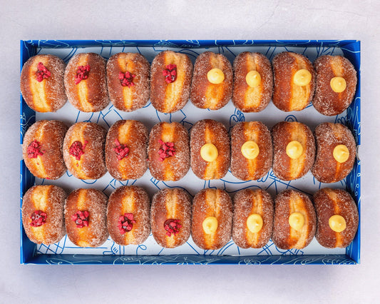 A box of mini doughnuts with vanilla custard and raspberry jam fillings.