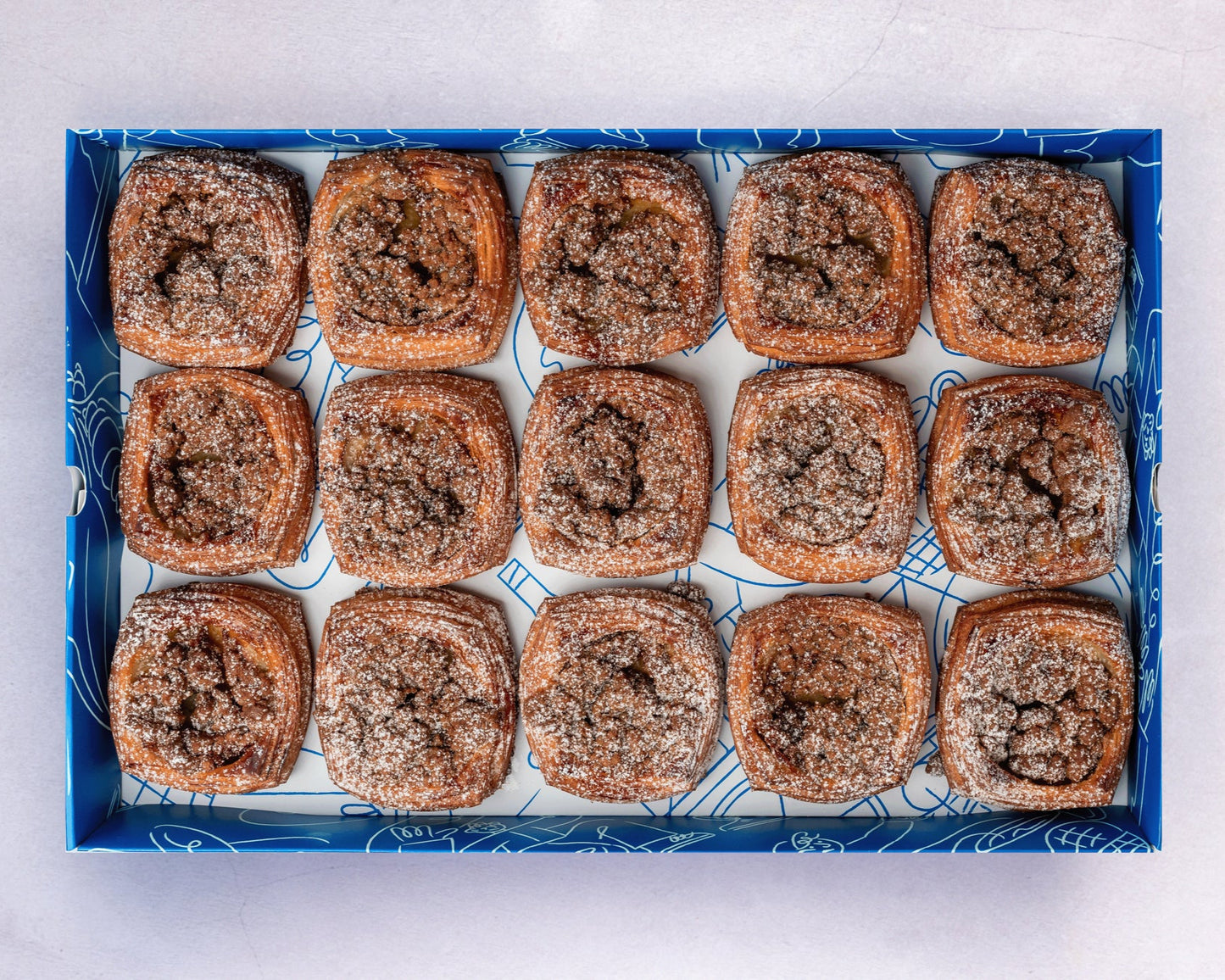 A box of Bakehouse Occasions mini banana caramel crumble danish with salted caramel drizzle.
